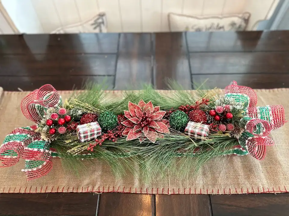 Christmas table runner of pine, poinsettias, berries and plaid ribbon