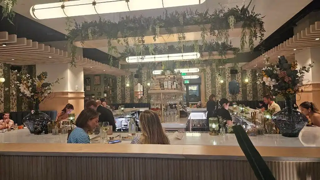 Dinner and drinks at Flora in Charlotte beneath suspended faux greenery and statement flower arrangements