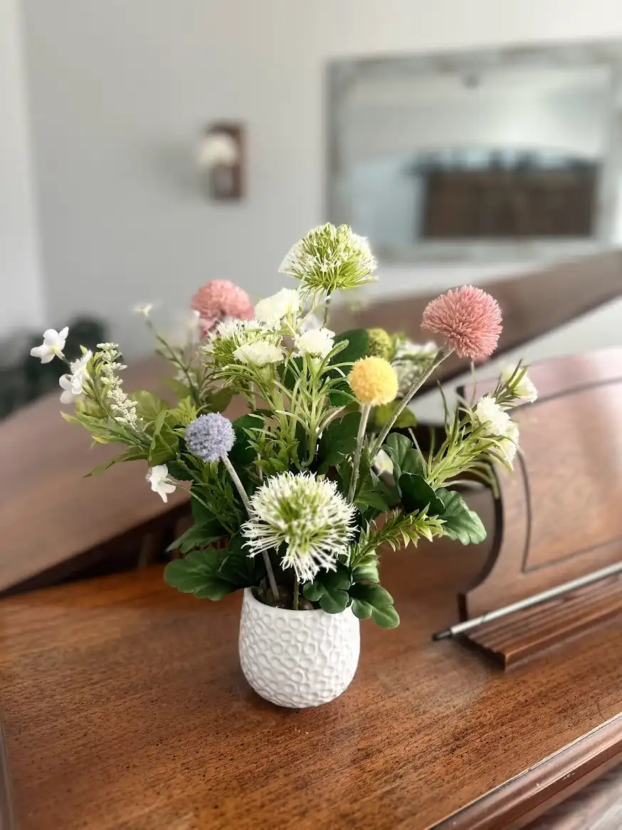 Pastel birthday arrangement with billy balls, daisies and greenery in a white pot