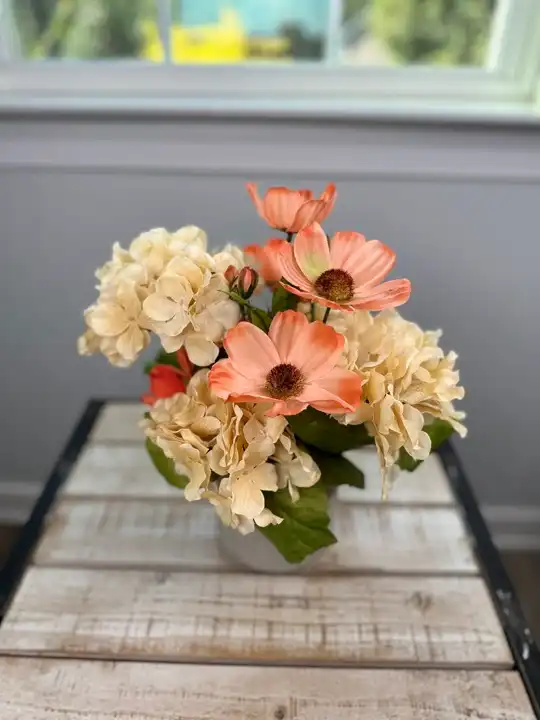 Peach gerbera daisies with cream hydrangea in a low vase