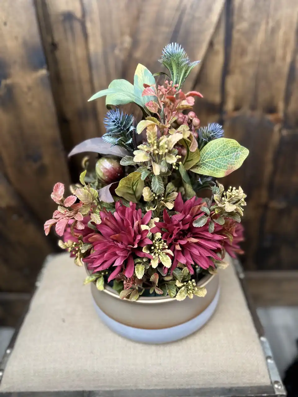 Round pink dahlia and berry centerpiece in a low ceramic bowl
