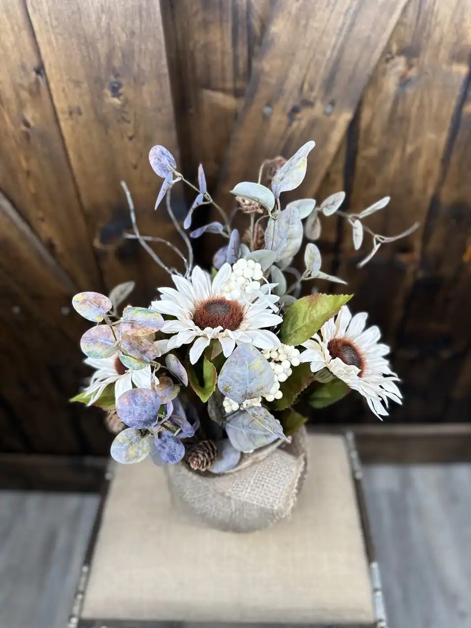 White sunflowers with dusty blue hydrangea and eucalyptus in a burlap wrap